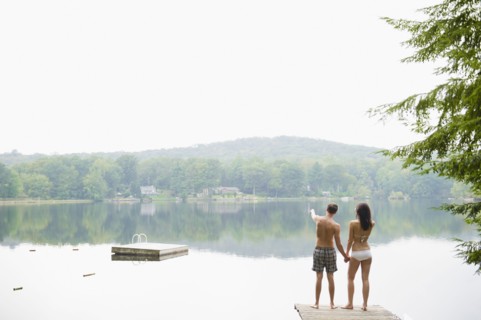 USA, New York, Putnam Valley, Roaring Brook Lake, Couple standing on pier by lake. Photo: Jamie