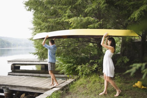 Roaring Brook Lake, Couple carrying boat by lake. Photo: Jamie Grill