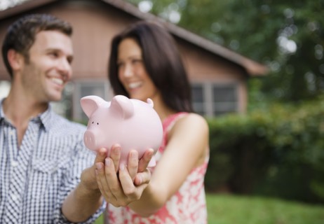 USA, New York, Putnam Valley, Roaring Brook Lake, Couple holding piggy bank. Photo: Jamie Grill