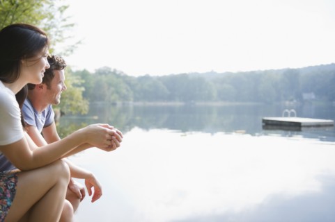 USA, New York, Putnam Valley, Roaring Brook Lake, Couple sitting by lake. Photo: Jamie Grill