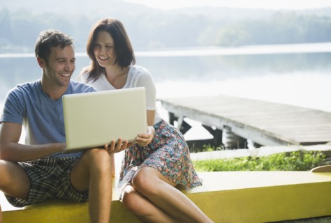 Roaring Brook Lake, Couple using laptop by lake. Photo: Jamie Grill