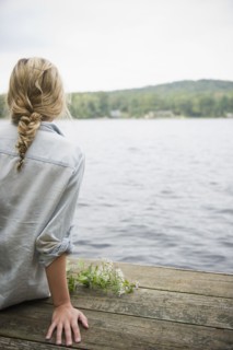 USA, New York, Putnam Valley, Roaring Brook Lake, Rear view of woman sitting on pier by lake.