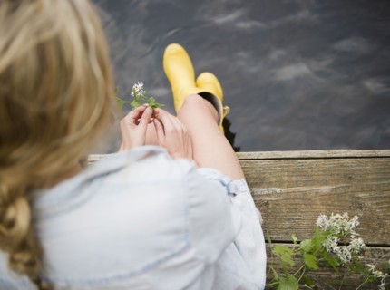 Roaring Brook Lake, Rear view of woman sitting on pier by lake. Photo: Jamie Grill