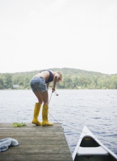 USA, New York, Putnam Valley, Roaring Brook Lake, Rear view of woman mooring boat. Photo : Jamie