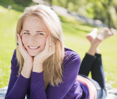 USA, New York, New York City, Manhattan, Central Park, Young woman lying on grass. Photo : Daniel