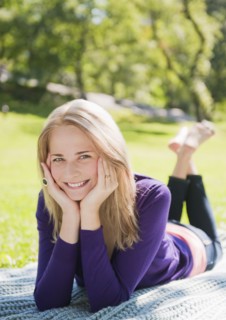 USA, New York, New York City, Manhattan, Central Park, Young woman lying on grass. Photo : Daniel