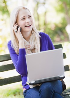 USA, New York, New York City, Manhattan, Central Park, Young woman sitting on bench with laptop and