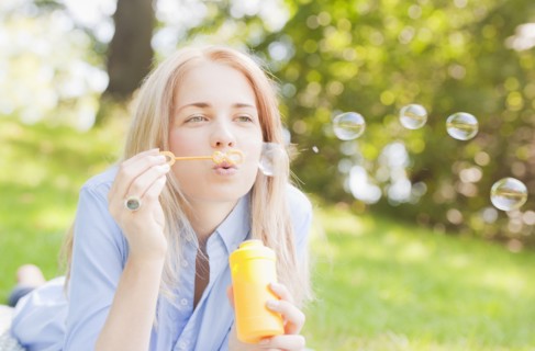 USA, New York, New York City, Manhattan, Central Park, Woman blowing bubbles. Photo: Daniel Grill