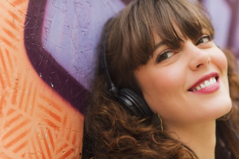 Portrait of smiling woman with headphones. Photo: Daniel Grill