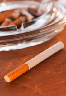Close up of cigarette and glass ashtray. Photo : Daniel Grill