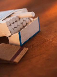 Close up of open cigarette pack and matches. Photo : Daniel Grill