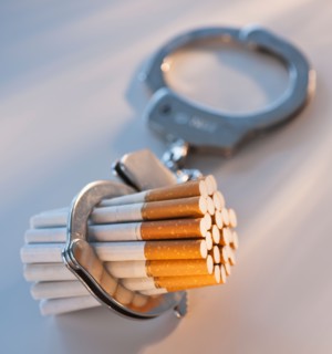 Close up of bunch of cigarettes locked in handcuffs. Photo : Daniel Grill