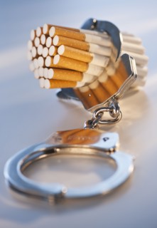 Close up of bunch of cigarettes locked in handcuffs. Photo : Daniel Grill