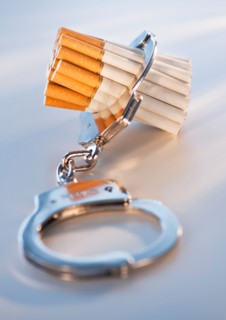 Close up of bunch of cigarettes locked in handcuffs. Photo : Daniel Grill
