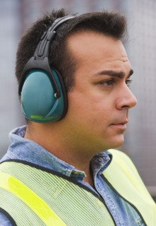 Construction worker wearing reflective clothing and headphones. Photo : Daniel Grill
