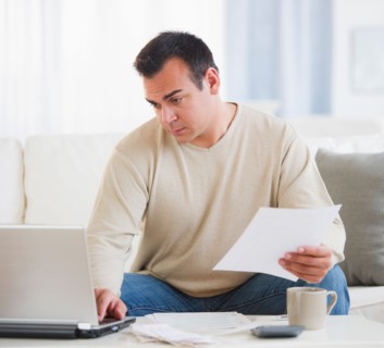 Portrait of man doing paperwork in living room. Photo : Daniel Grill