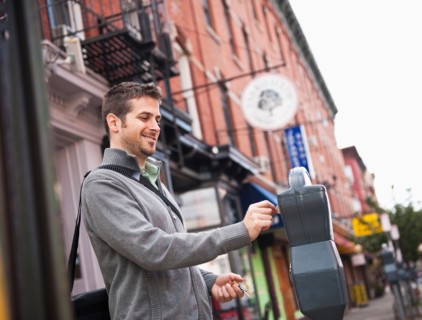Man inserting coin to parking meter. Photo: Daniel Grill