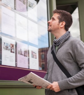Man with newspaper looking at advert display. Photo: Daniel Grill