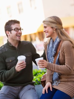 Young couple sitting with take-away coffee. Photo : Daniel Grill