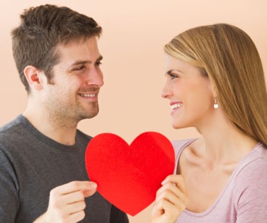 Couple holding red paper heart. Photo : Daniel Grill