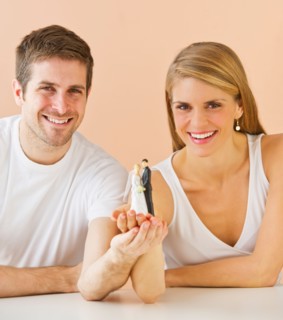 Couple holding small wedding figurine. Photo : Daniel Grill