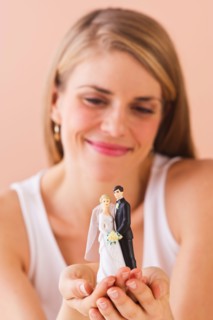 Young woman holding wedding figurine. Photo : Daniel Grill