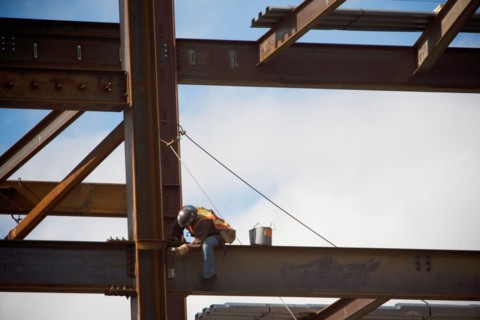 Construction worker working on unfinished structure. Photo : fotog