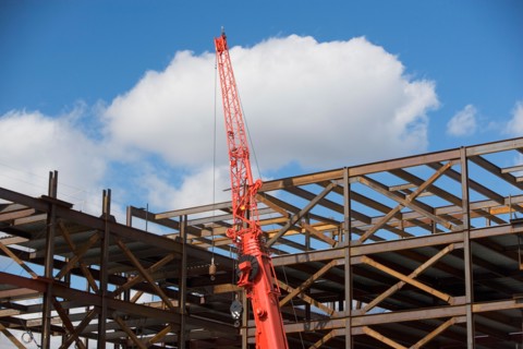 Unfinished structure and crane at construction site. Photo : fotog