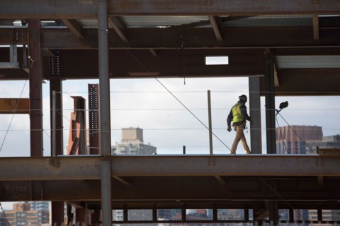 USA, New York City, Construction worker walking inside of unfinished structure. Photo : fotog