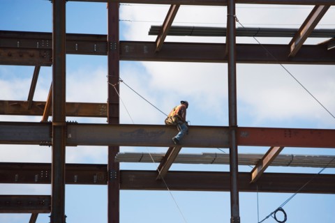 Construction worker working on unfinished structure. Photo : fotog