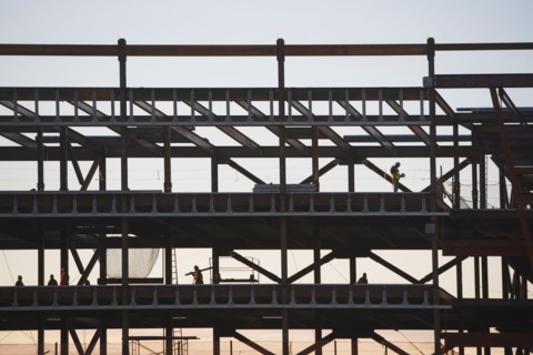 Group oaf construction workers working on unfinished structure. Photo : fotog