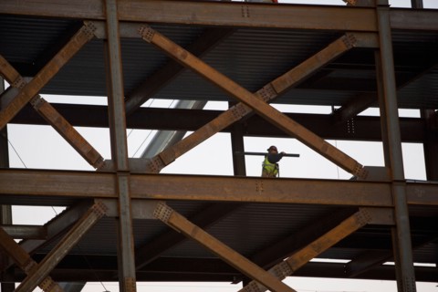 Construction worker working on unfinished structure. Photo : fotog
