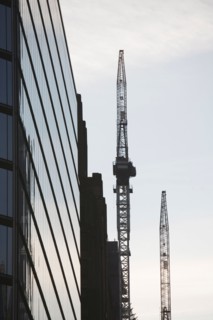 USA, New York City, Modern office building and cranes in background. Photo : fotog