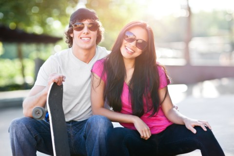 Young multi-racial couple posing with skateboard. Photo : Take A Pix Media