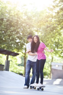 Young multi racial couple skateboarding. Photo : Take A Pix Media