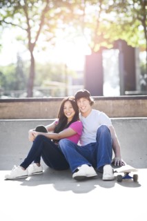 Young multi-racial couple posing with skateboard. Photo : Take A Pix Media