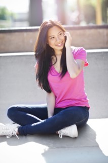 Young chinese woman using mobile phone outdoors. Photo : Take A Pix Media