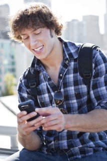 USA, Washington, Seattle, Man text messaging outdoors. Photo: Take A Pix Media