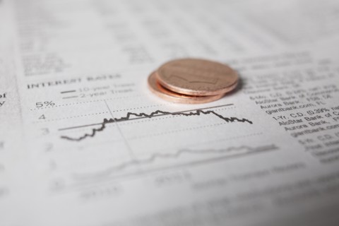 Studio shot of coins on financial newspaper. Photo : Winslow Productions