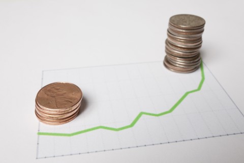 Coins on sheet of paper with graph. Photo : Winslow Productions