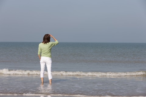 Woman on beach looking out to sea. Photo : Jan Scherders