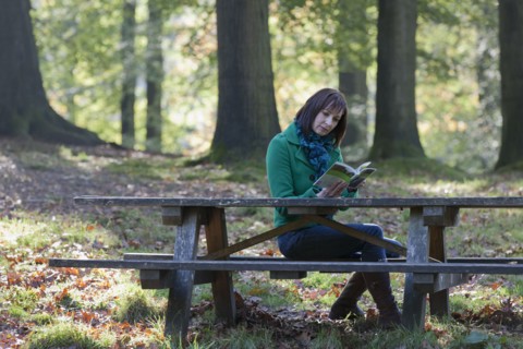 The Netherlands, Veluwezoom, Posbank, Woman reading book in park. Photo : Jan Scherders