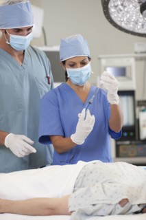 Surgeons preparing patient for surgery. Photo : db2stock