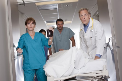 Team of doctors wheeling in patient. Photo : db2stock