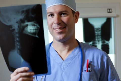 Portrait of male doctor looking at x-ray. Photo: db2stock