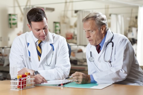 Two doctors reading medical document in hospital. Photo : db2stock