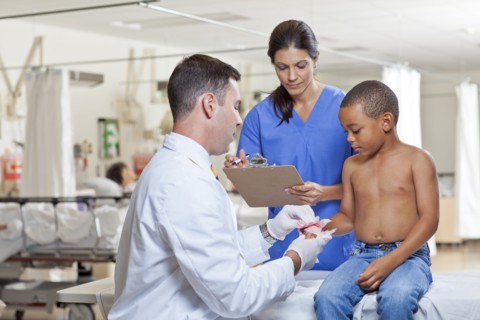 Doctors applying bandage on boy's (4-5) hand. Photo: db2stock