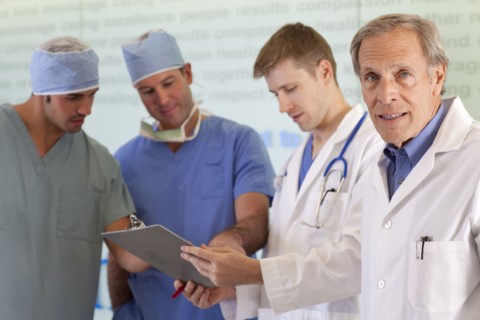 Doctors and surgeons discussing on medical record. Photo : db2stock