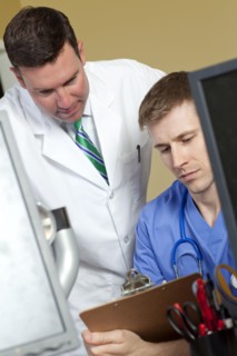 Doctor and surgeon reading medical record in doctor's office. Photo : db2stock