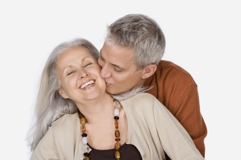 Studio shot of mature man kissing woman. Photo : Rob Lewine